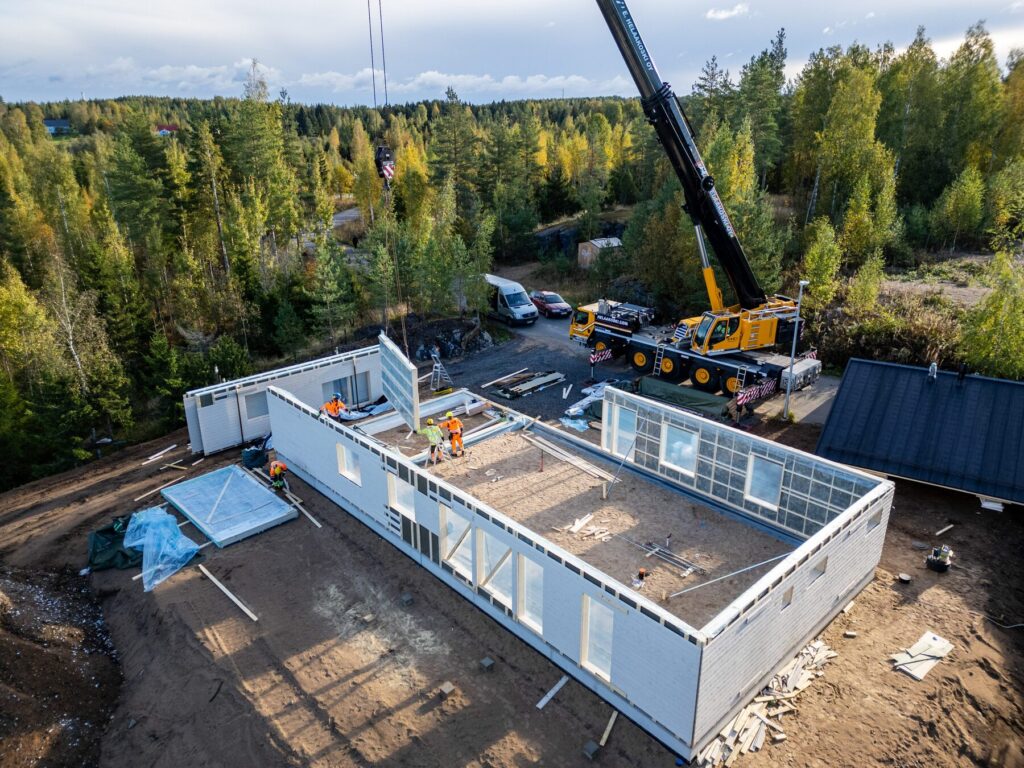 Talopaketin seinäelementin asennus nosturilla Fin-Talon työmaalla