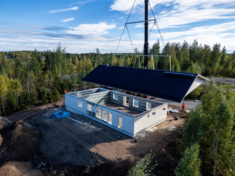 Omakotitalon vesikatto asennetaan nosturilla työmaalla